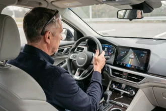 Ingénieur automobile observant les systèmes d'assistance à la conduite sur l'écran central d'une voiture moderne